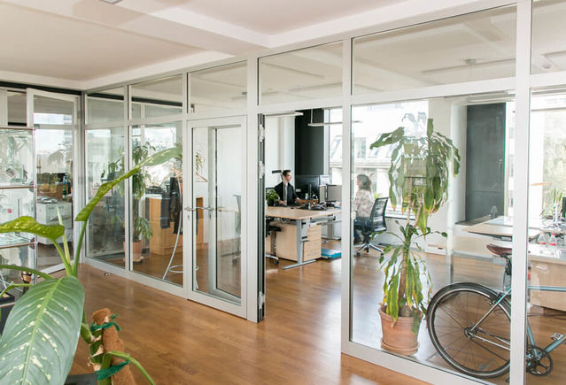 Höhenverstellbare Tische, bequeme Stühle, viele Pflanzen und großzügige Büroräume machen das Arbeiten gleich viel schöner.