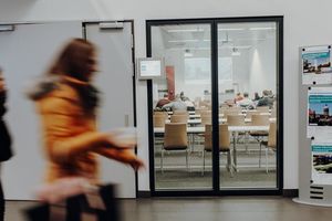 Flur der FOM vor einem Hoersaal mit Studierenden auf dem Weg zur naechsten Vorlesung