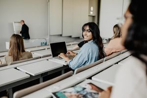 Sitzreihe in Hoersaal der FOM mit weiblichen Studierenden sitzend mit Laptop