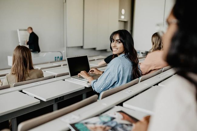 Sitzreihe in Hoersaal der FOM mit weiblichen Studierenden sitzend mit Laptop