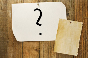 Papier mit Fragezeichen an Holz gepinnt