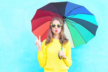 Studentin steht unter einem Regenschirm