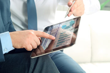 Ein Gesundheitsökonom wertet auf einem Tablet Gesundheitsdaten aus.